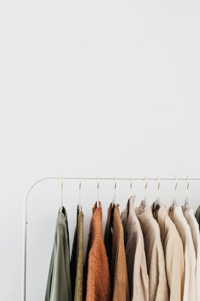 Muted color shirts on hangers on rack in room