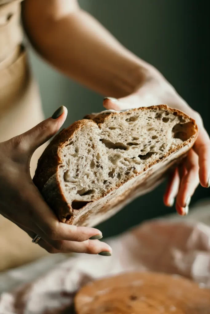 Hands holding freshly baked sourdough cut in half