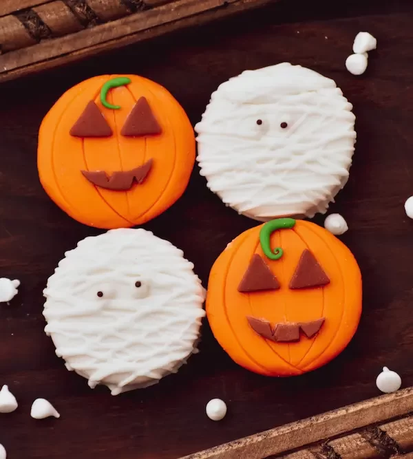 halloween cookies decorated like pumpkins and mummies