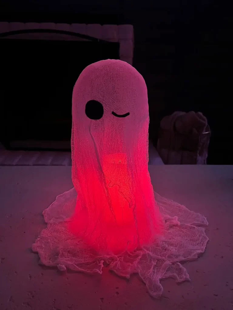 cheesecloth ghost lit up at night on coffee table in house