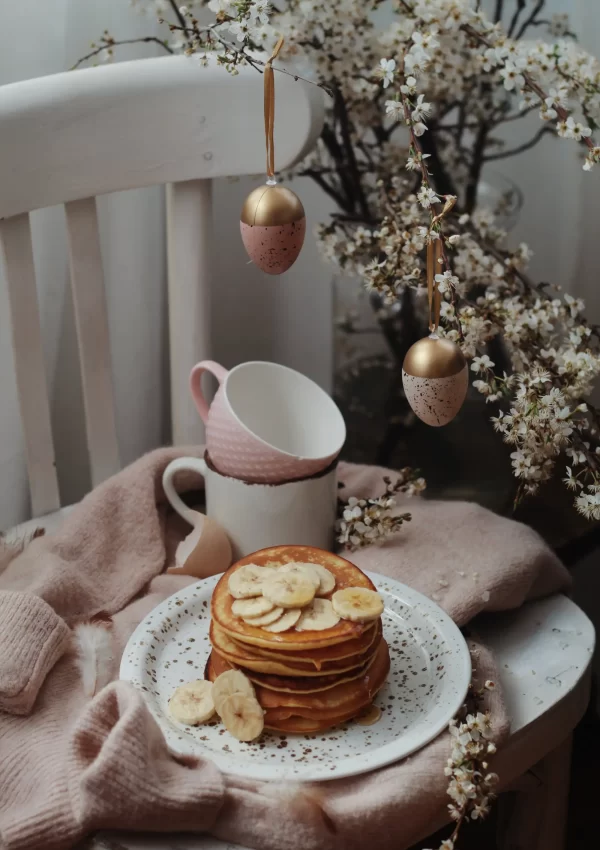 Pancakes, teacups, and easter eggs hanging from tree in background