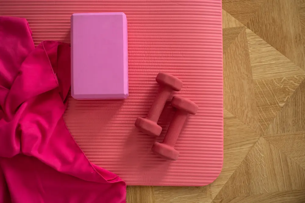 pink dumbbells and yoga mat