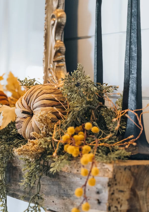 fall decorations sitting on top of a wooden mantel